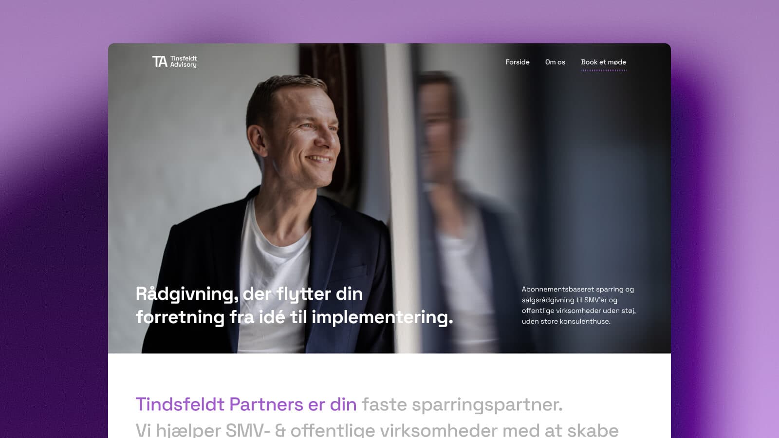 Smilende mand i mørk jakkesæt kigger ud af vindue med refleksion i glasset.