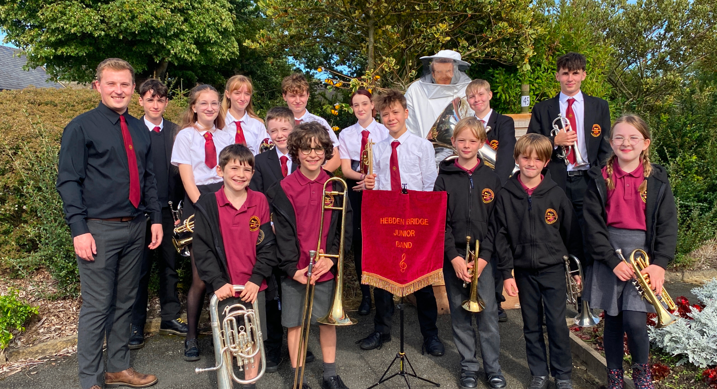 Hebden Bridge Junior Band members with the band banner at the Norland Scarecrow Festival
