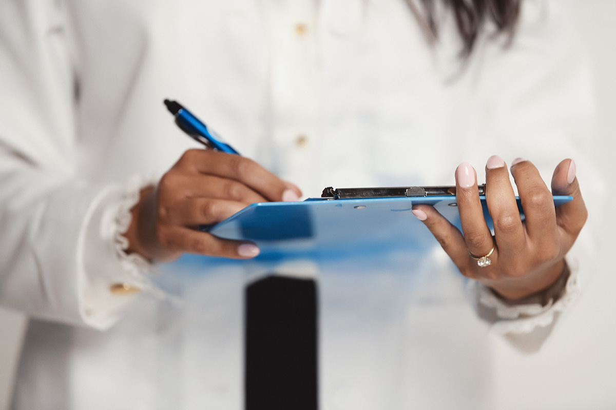 Close up photo of hands holding a clipboard and pen