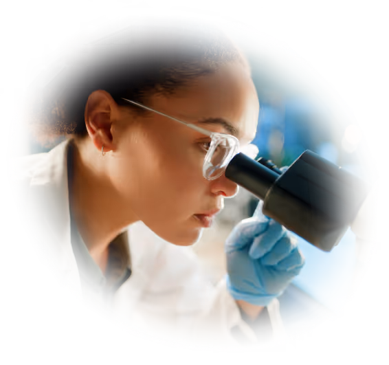 scientist looking through microscope