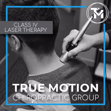 Therapist applying Class IV laser therapy to a man's neck and shoulder area at True Motion Chiropractic Group.