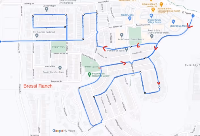Map of Bressi Ranch neighborhood in Carlsbad with a blue route marked by dots and red arrows showing a travel path through streets including Topiary Park, Garden House Rd, and Melrose Dr.