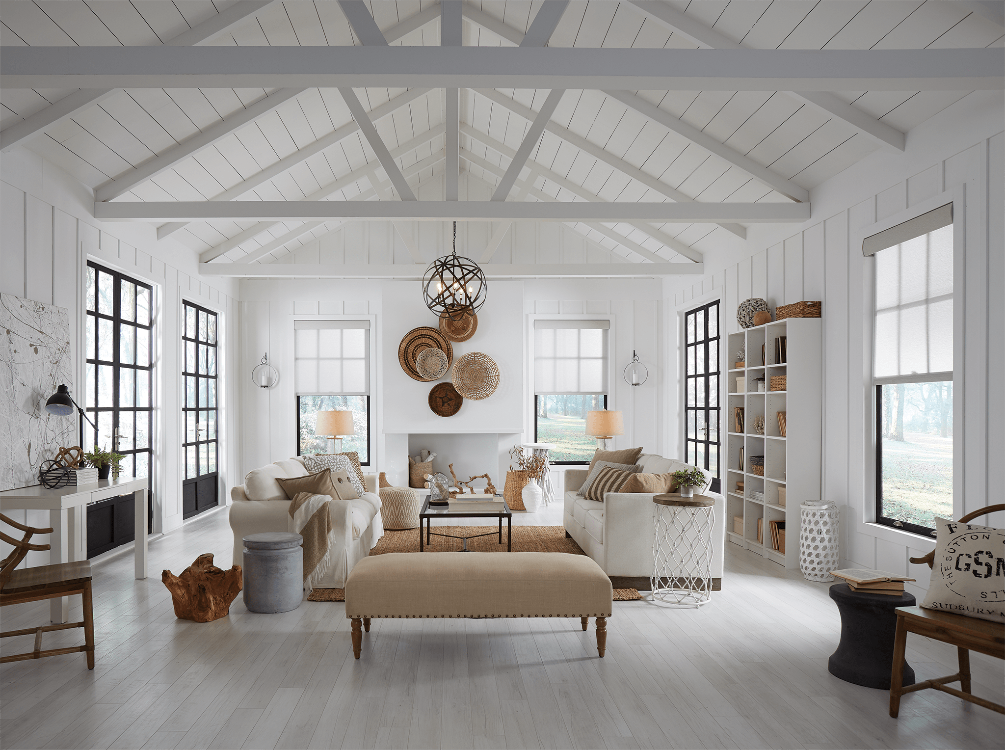 Farmhouse with white floors, walls and ceilings.  Open rafters give this room lots of space.