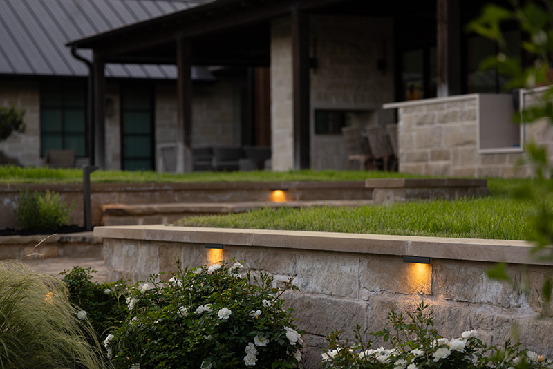 Backyard with low voltage landscape lighting around the retaining walls.