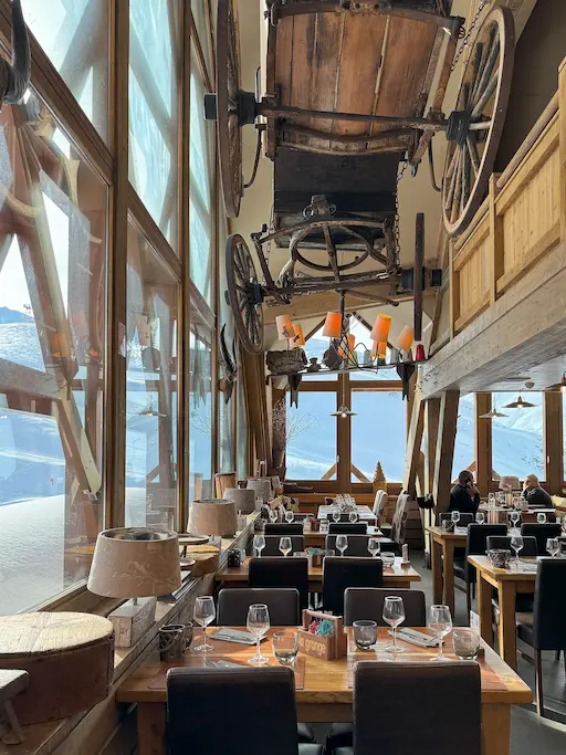 Ambiance chaleureuse du bar du restaurant La Grange, avec verres, bois et éclairage tamisé.