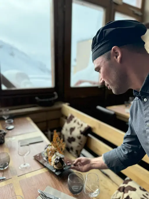 Intérieur du bar du restaurant La Grange, avec bouteilles en arrière-plan et atmosphère conviviale.