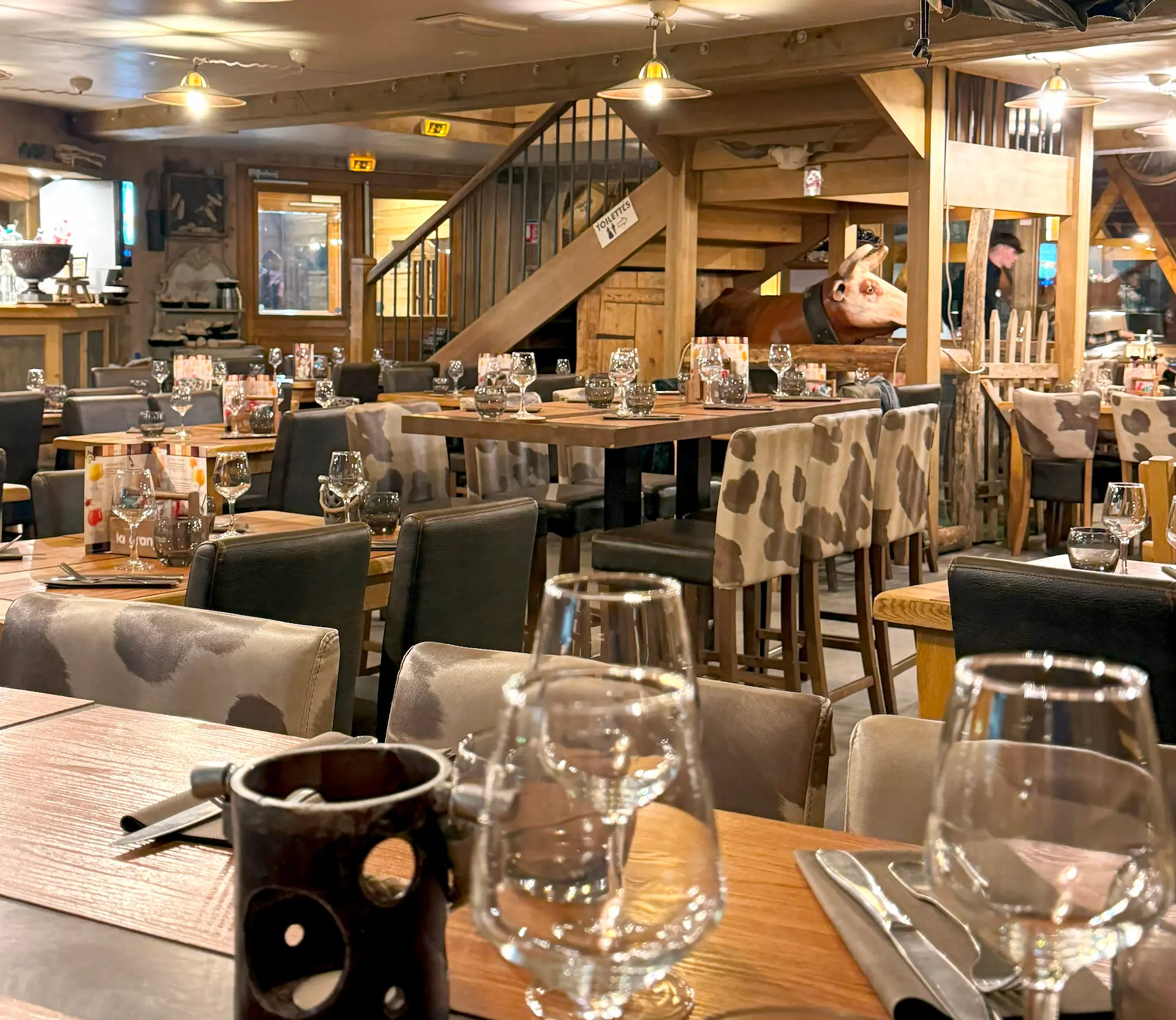 Vue rapprochée du comptoir du bar, mettant en valeur les détails en bois et la décoration rustique.