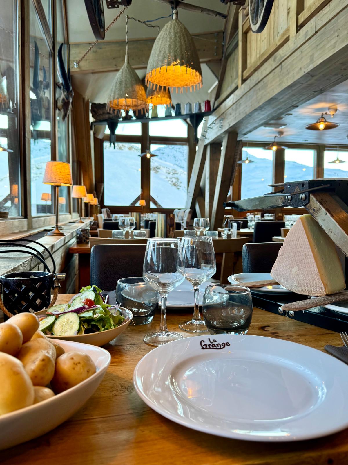 Ambiance chaleureuse du bar du restaurant La Grange, avec verres, bois et éclairage tamisé.