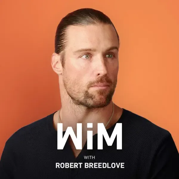 Portrait of a man with slicked-back hair and a beard wearing a dark shirt against an orange background, with text 'WiM with Robert Breedlove'.