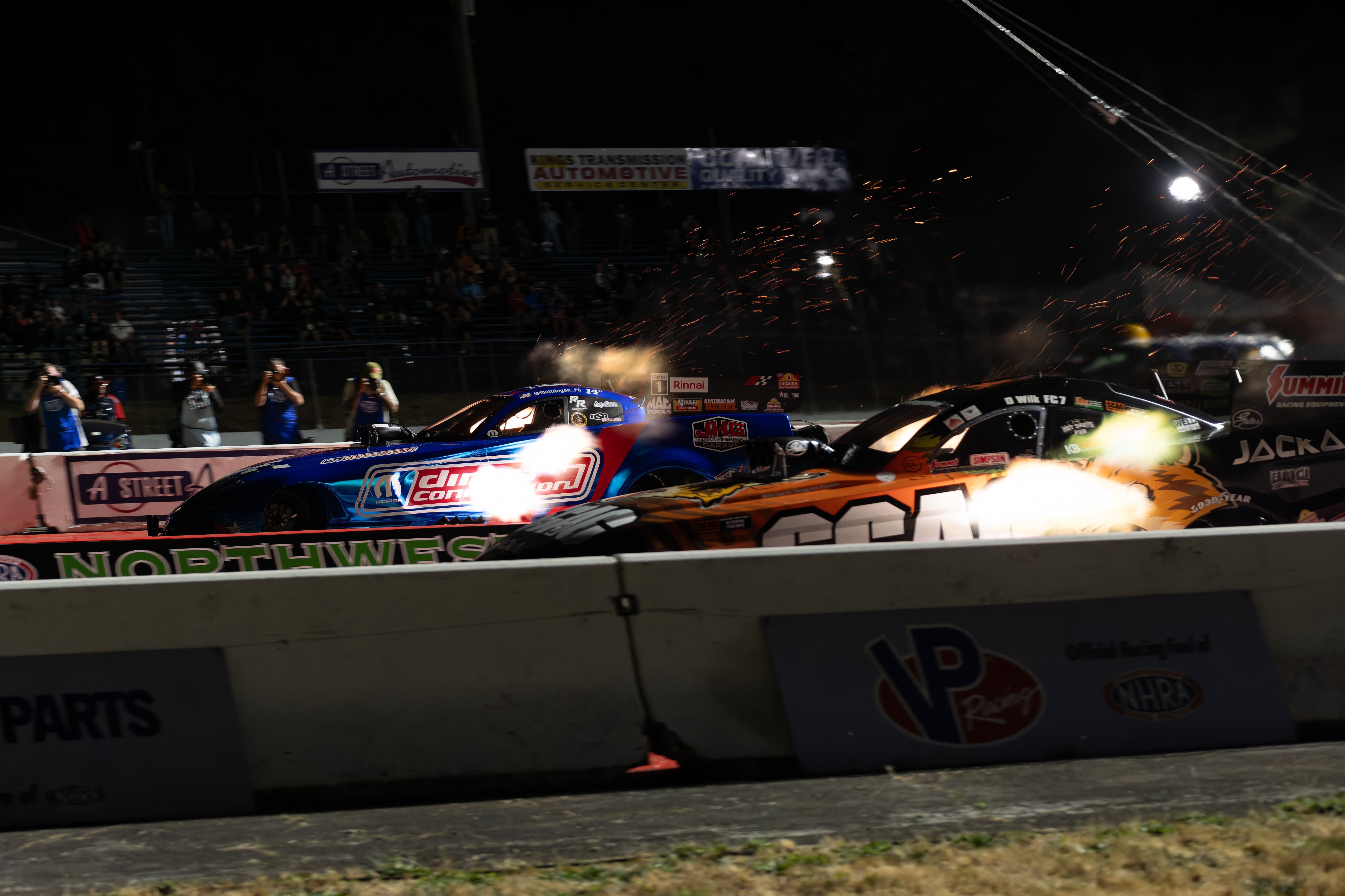 Blue sports car performing a burnout on a racetrack with smoke around the rear tires with Streetcar Addiction