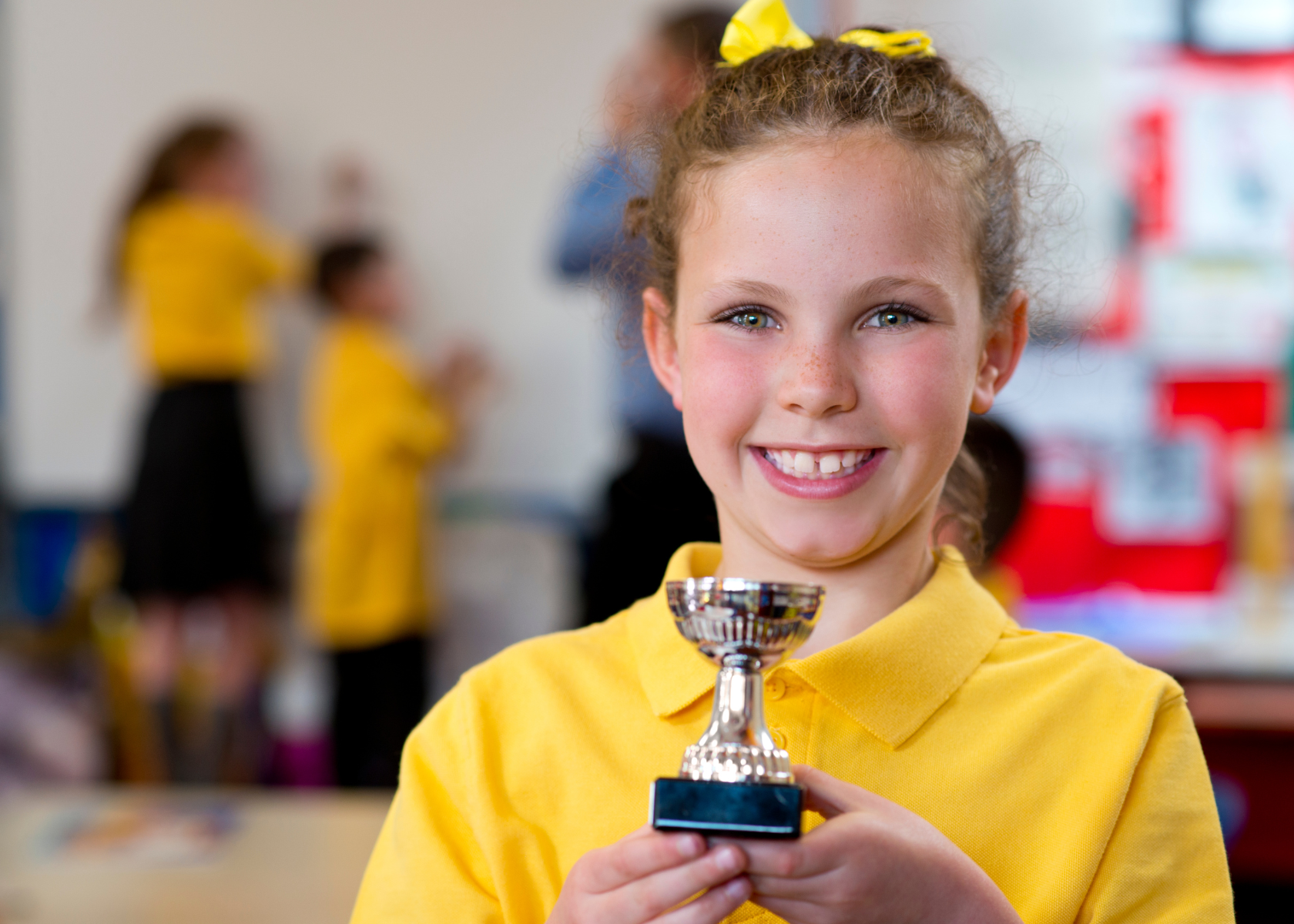 Primary school student holding award, representing success.
