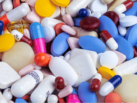 Close-up of various colorful pills and capsules including tablets in blue, white, yellow, pink, and red to represent Citivets on-site pharmacy