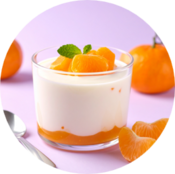 Glass of layered yogurt dessert topped with mandarin segments and mint, surrounded by mandarins