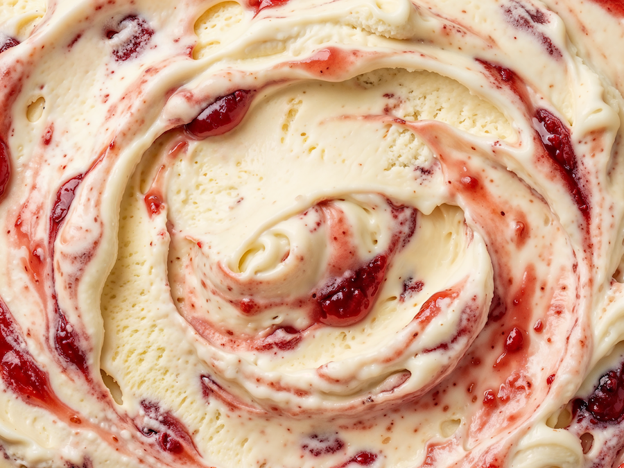 Nahaufnahme von Vanilleeis mit rotem Erdbeer-Swirl