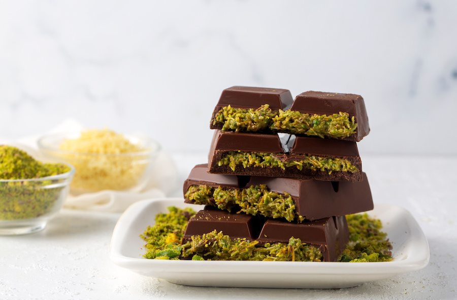 Stacked pieces of chocolate bar filled with green pistachio cream and crispy kadayif