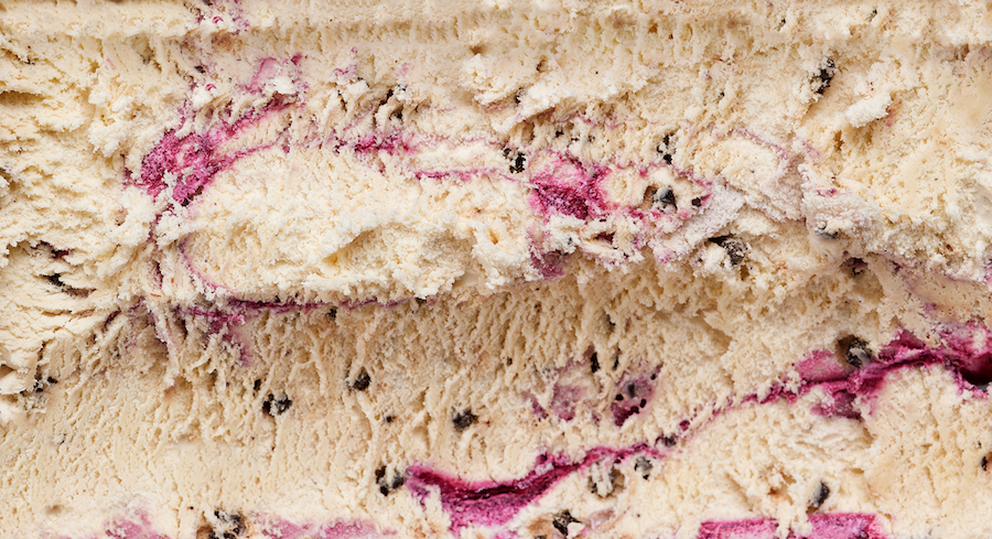 Nahaufnahme von Vanilleeis mit Beeren-Swirl und Schokoladenstückchen