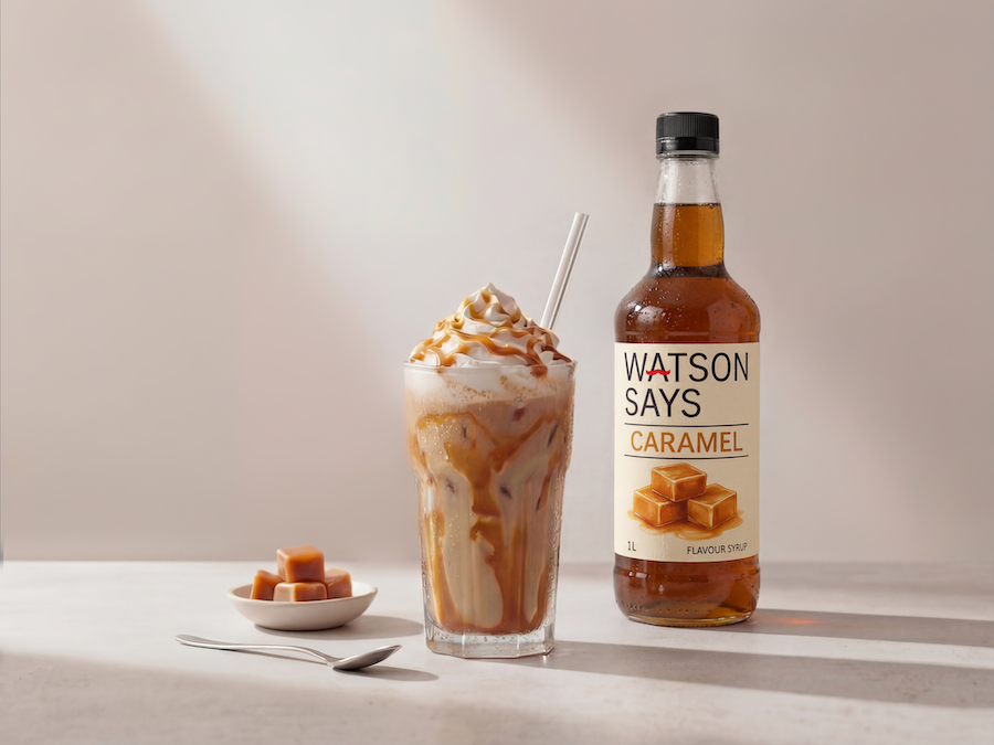Eis-Karamell-Frappé mit Schlagobers neben einer Flasche Watson Says Caramel Sirup