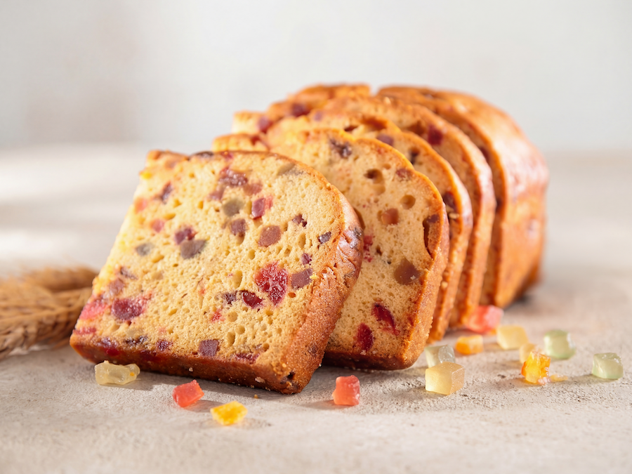 Slices of fruit bread with candied fruit pieces and scattered dried fruit
