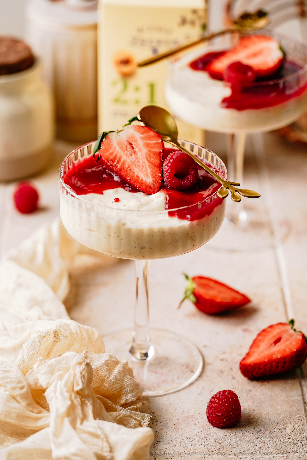Vanillecreme-Dessert im Coupe-Glas mit Erdbeersauce, frischen Erdbeeren und Himbeeren