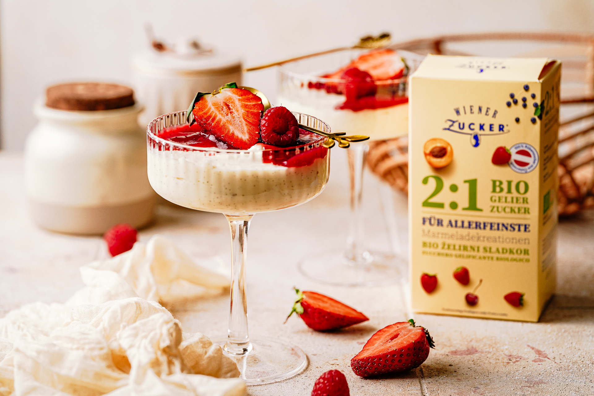 Packung Wiener Zucker 2:1 Bio Gelierzucker neben Erdbeer-Dessertgläsern und frischen Erdbeeren