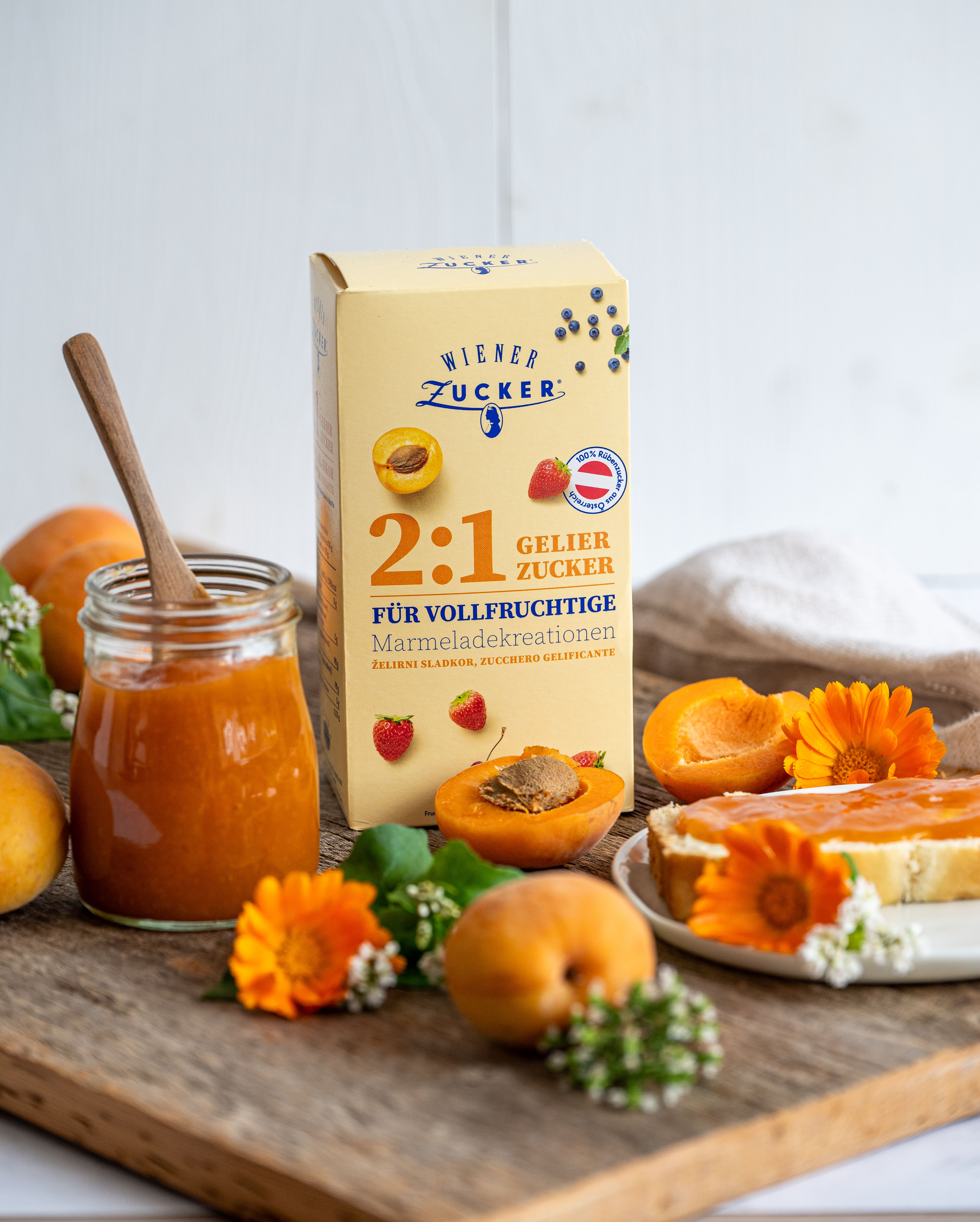 Packung Wiener Zucker 2:1 Gelierzucker mit Glas Marillenmarmelade, frischen Marillen und Brot mit Marmelade