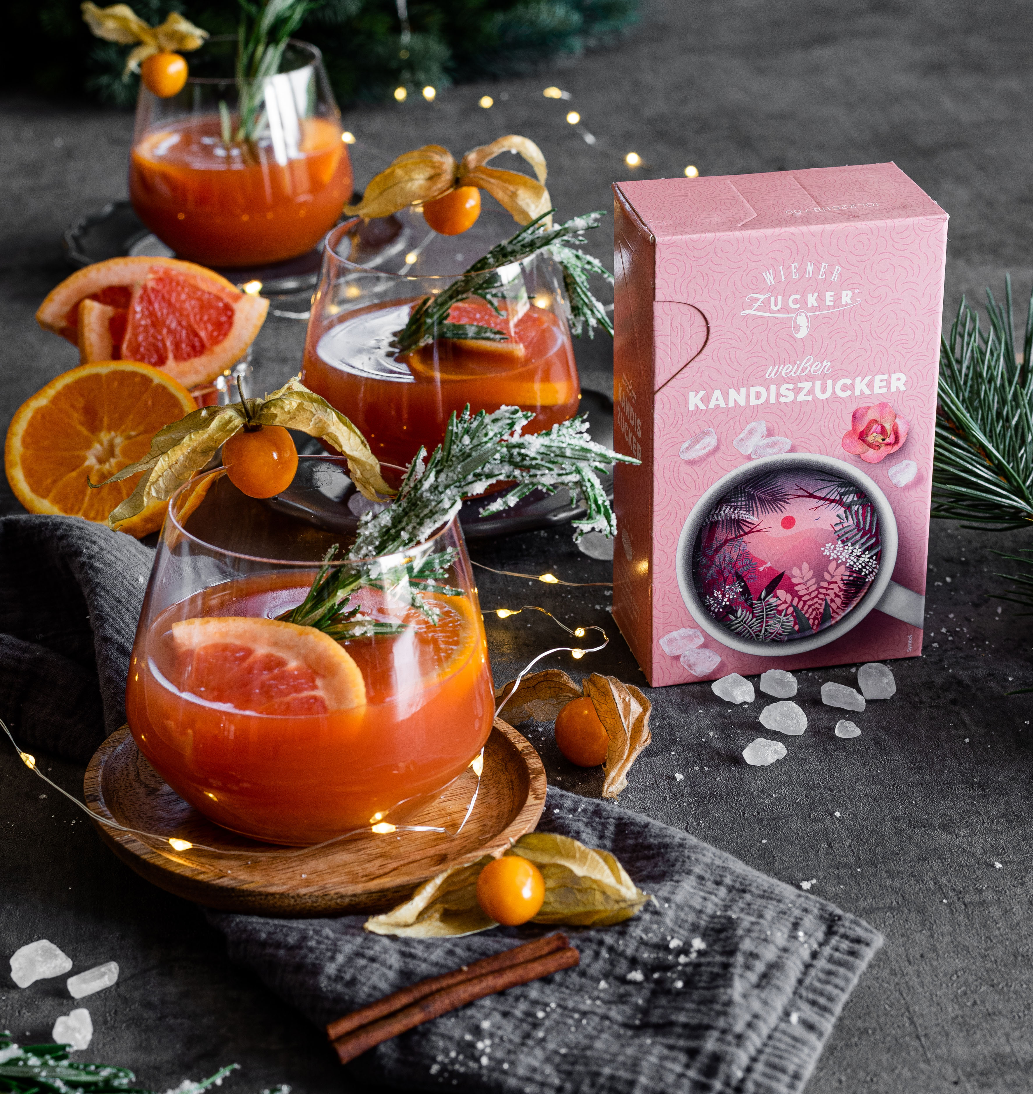 Gläser Orangenpunsch mit Grapefruit und Rosmarin neben einer Packung Wiener Zucker weißer Kandiszucker