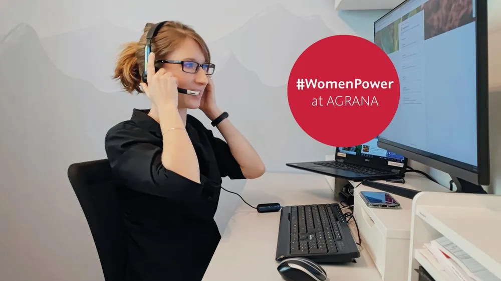 Yvonne Glaser, IT Specialist at AGRANA Holding, smiling at her desk with a headset, with the badge #WomenPower at AGRANA
