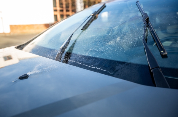 Scheibenwischer verteilen Wischwasser auf einer Autowindschutzscheibe