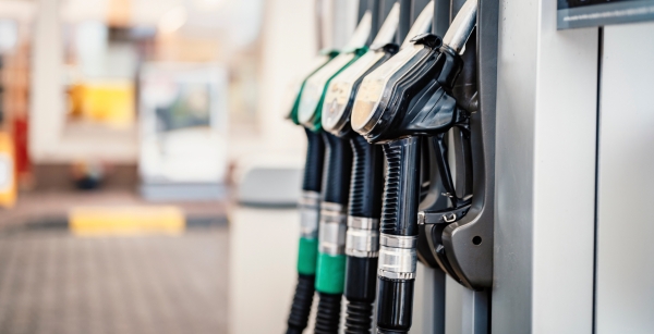 Row of fuel pump nozzles with green handles at a petrol station