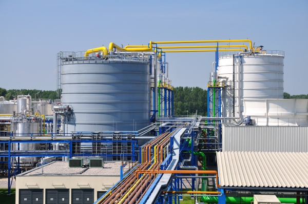 Large storage tanks and coloured pipelines of a bioethanol plant under a blue sky [no AI]