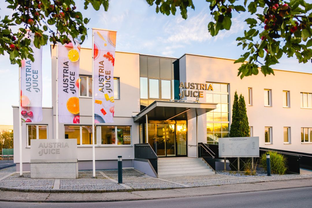 AUSTRIA JUICE Zentrale in Kröllendorf, Eingang mit Obst-Bannern im Abendlicht