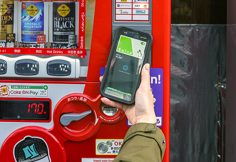 Photo of a phone showing a Suica transit card mobile payment at a Japanese vending machine