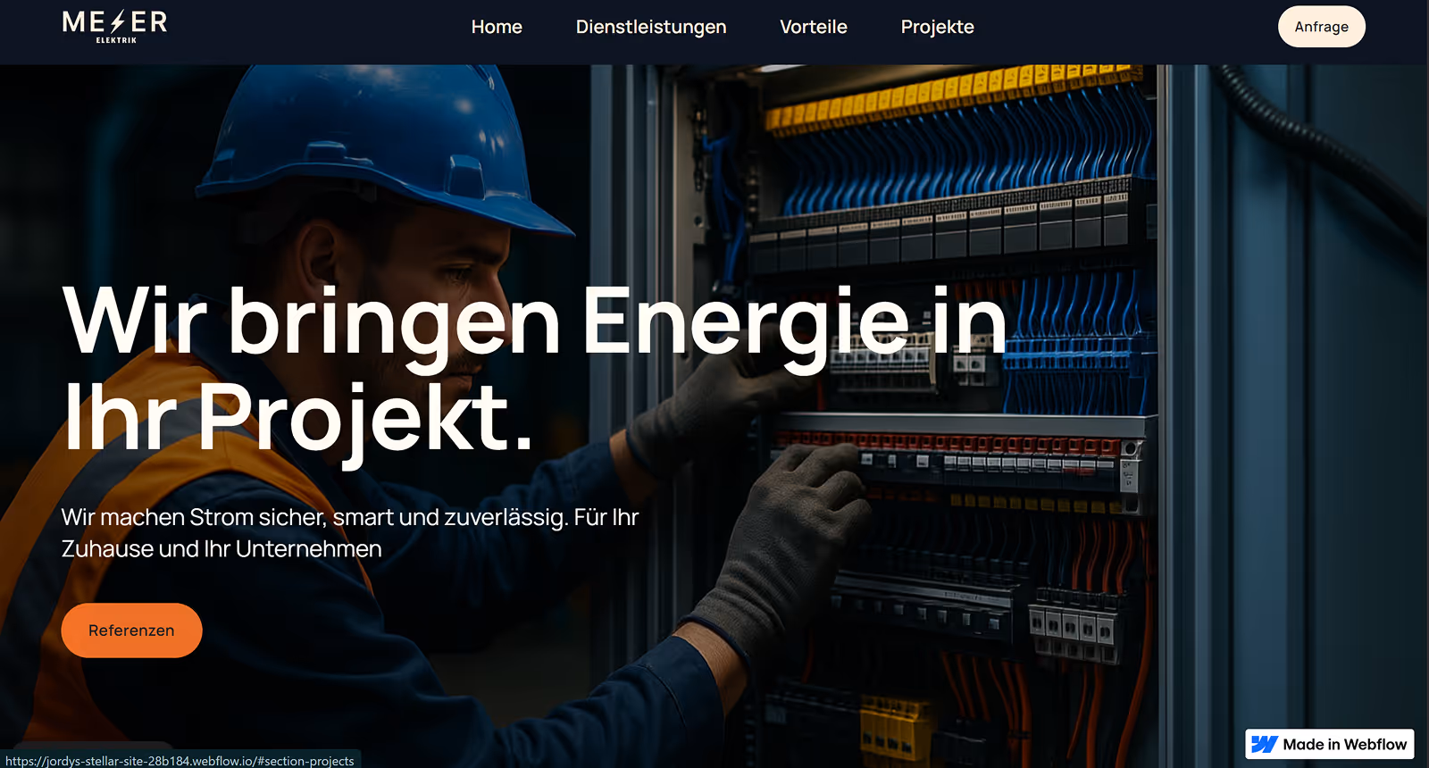 Electrician wearing a blue helmet and gloves working on an electrical panel with organized wiring.