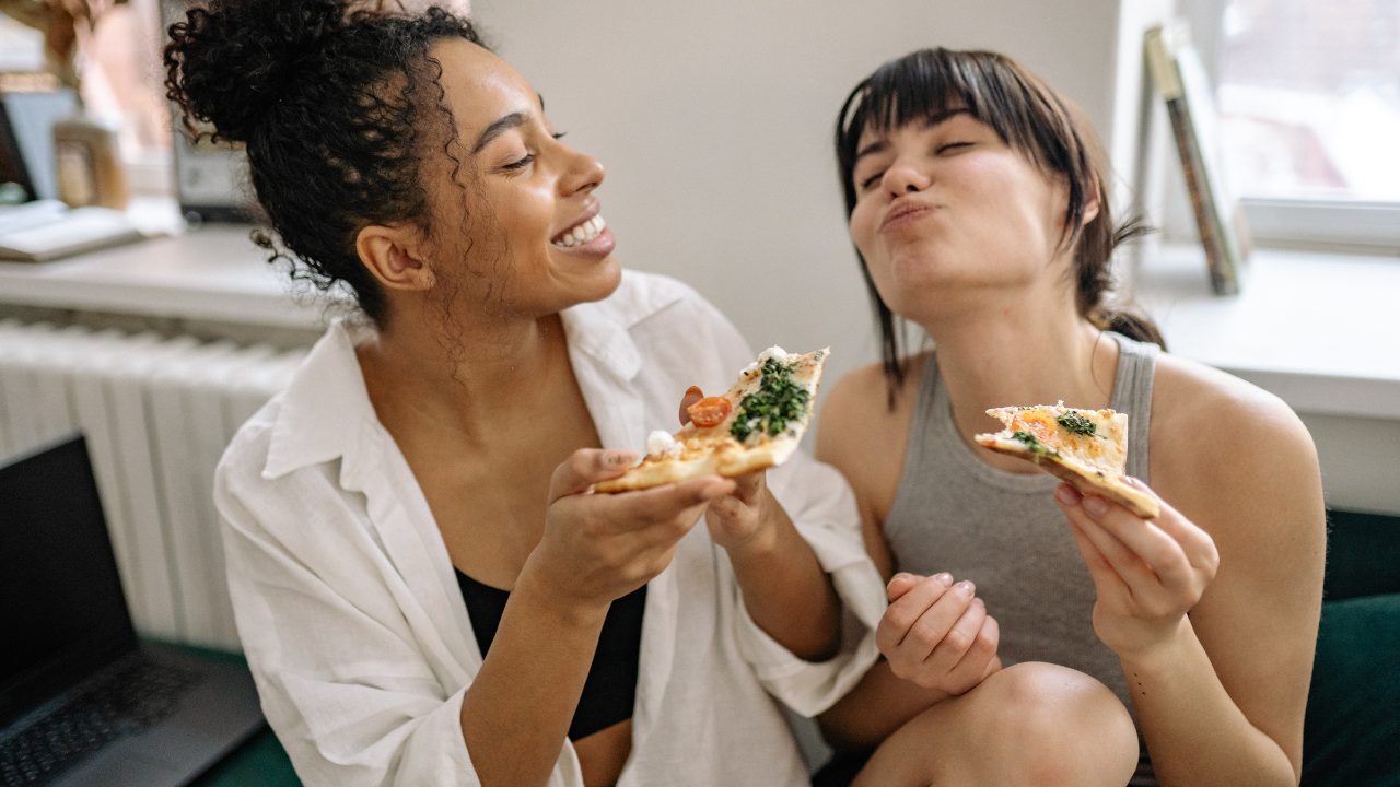 2 friends eating pizza together 