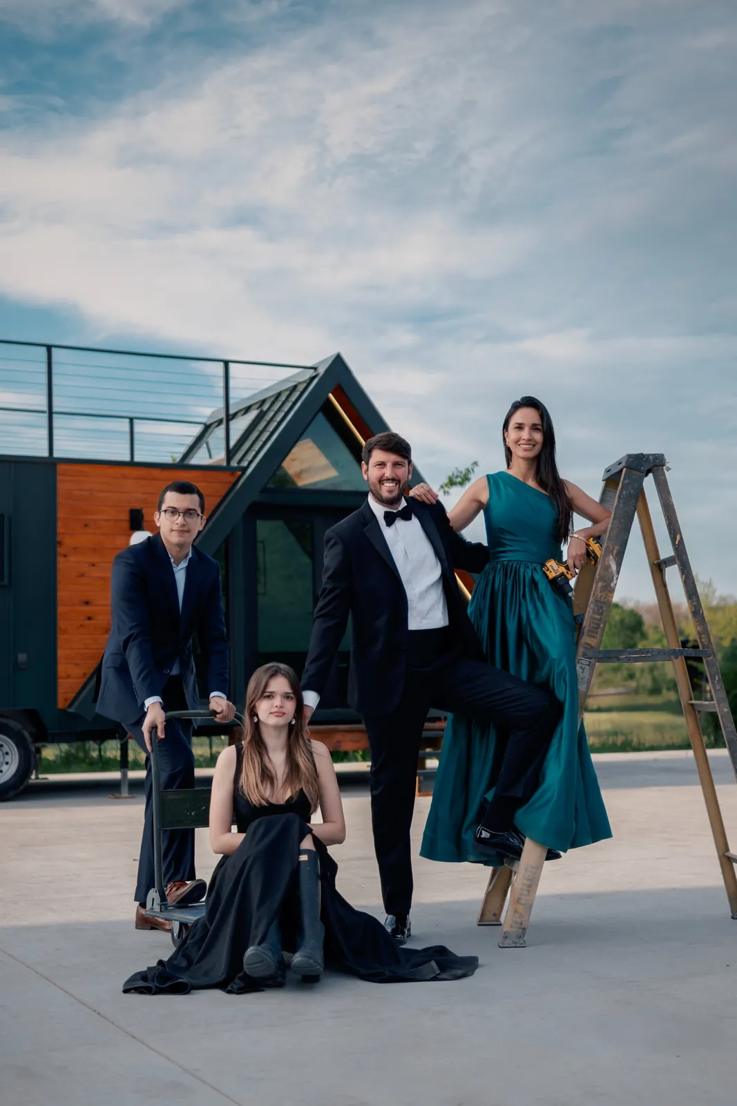 The Mainefactured family, dressed formally and holding builder's tools, in front of Casa Francesca