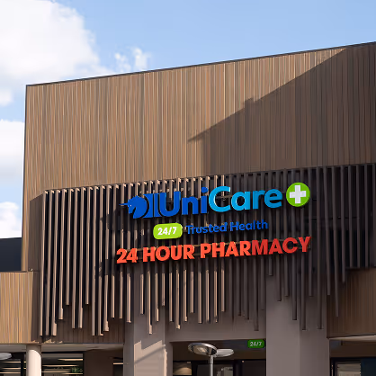 UniCare 24/7 Trusted Health 24 Hour Pharmacy sign on a modern building facade under a blue sky.