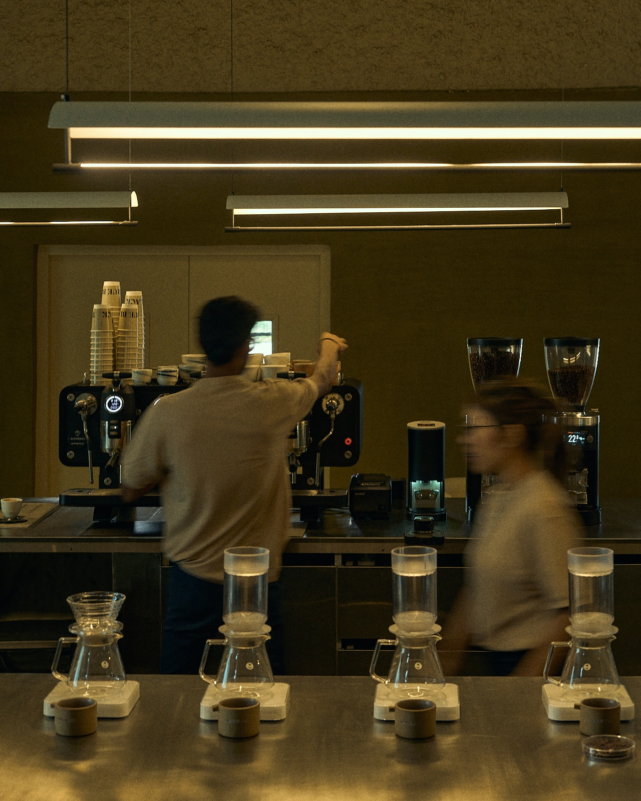 A Cafe where routine becomes a ritual and each material and form is purposeful. At the heart of the café sits a monolithic island counter, formed in rammed earth. 