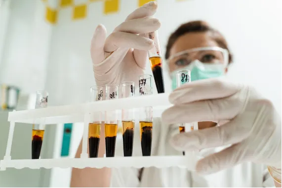 A woman in a lab holding a plasma tube.