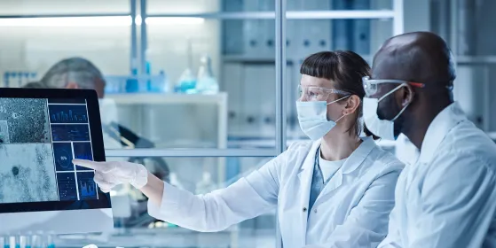 Two scientists looking at a computer screen in a laboratory