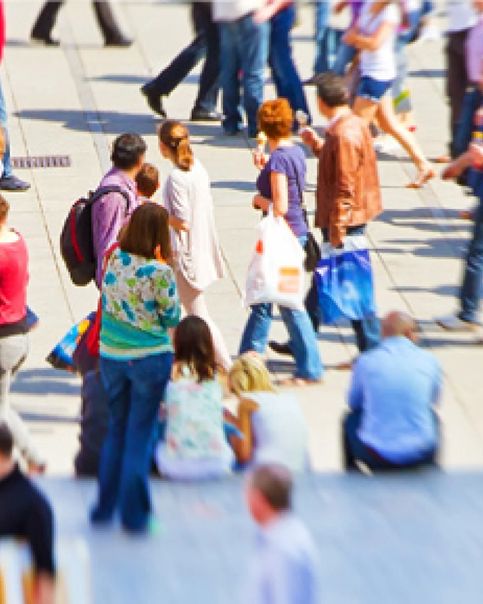 a crowd of people walking down a sidewalk