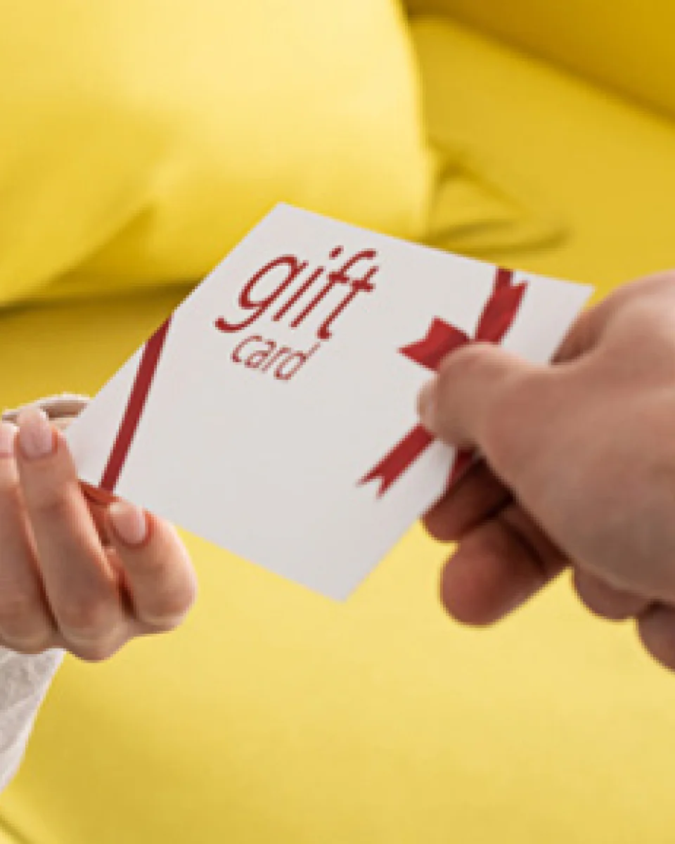 a person handing another person a gift card.