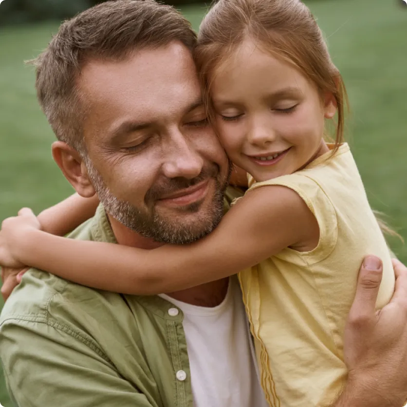 A man and his child are hugging each other