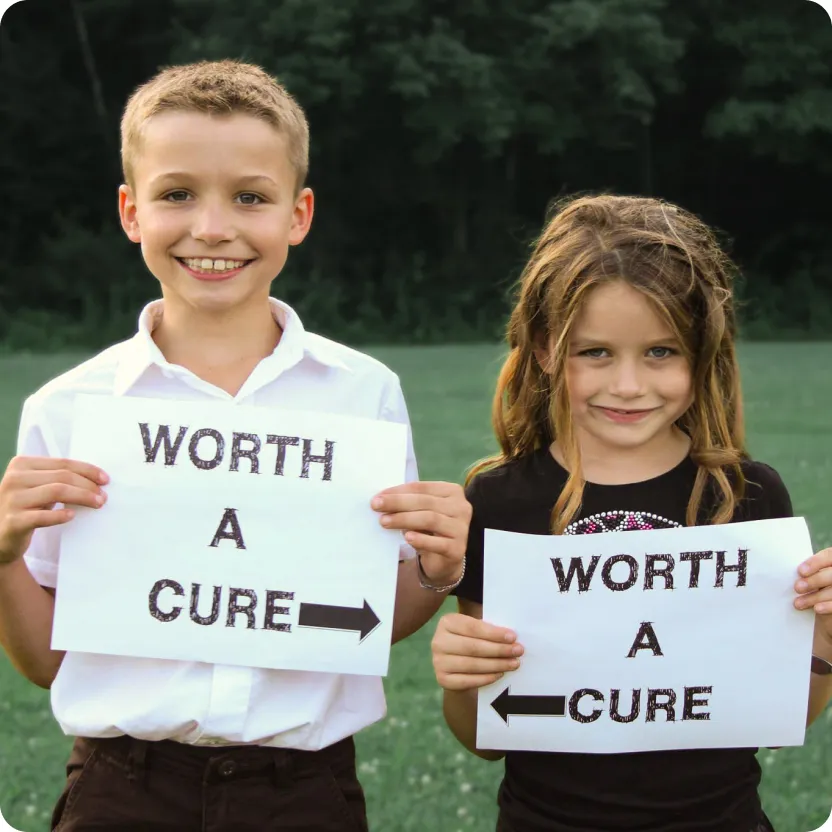 A boy and girl sibling are holding a paper that says: "Worth a cure"