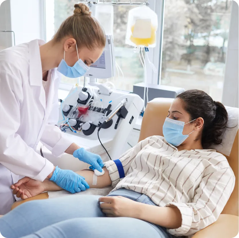 A young woman and her doctor during the plasma donation process.
