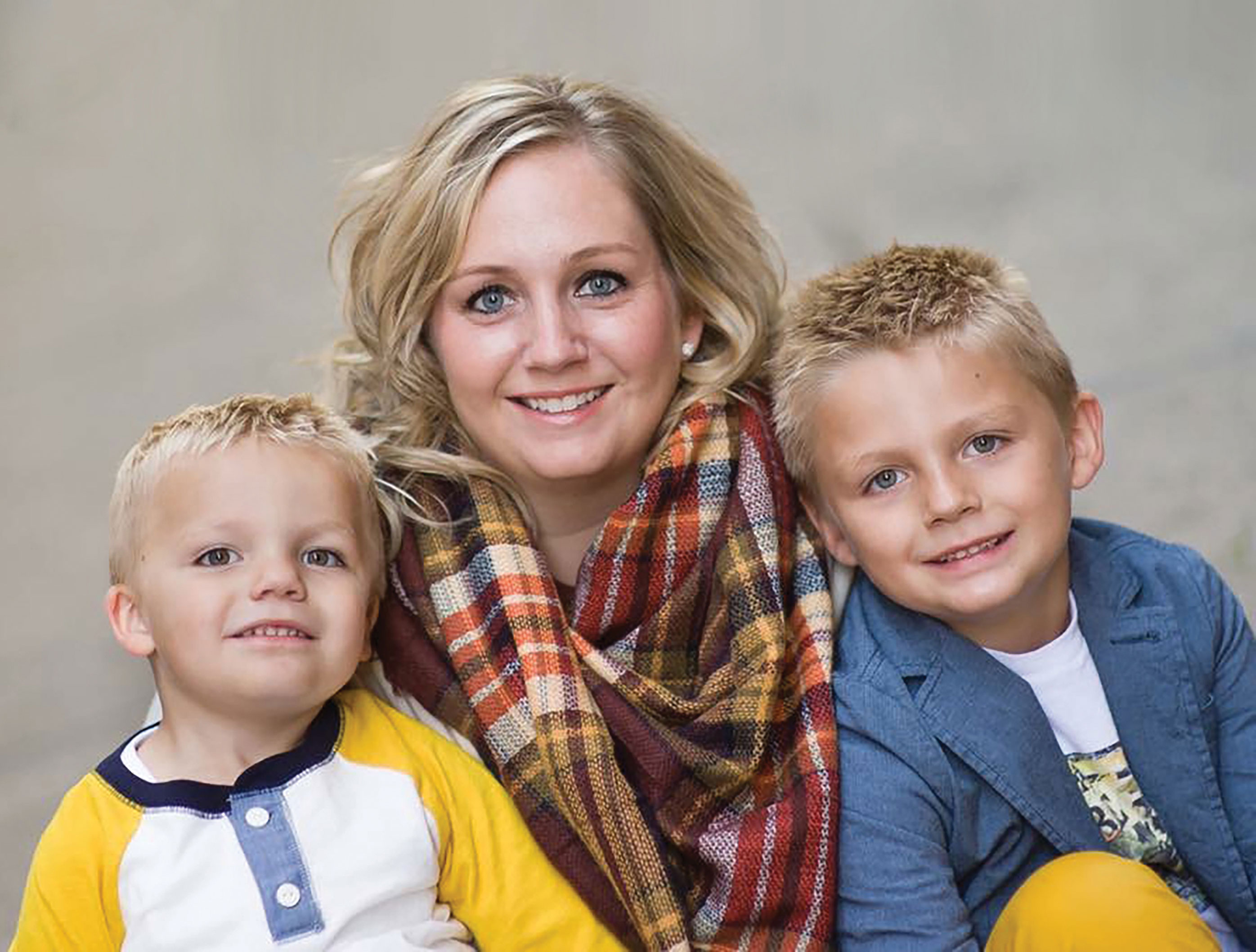 a woman and two little boys smiling for a picture
