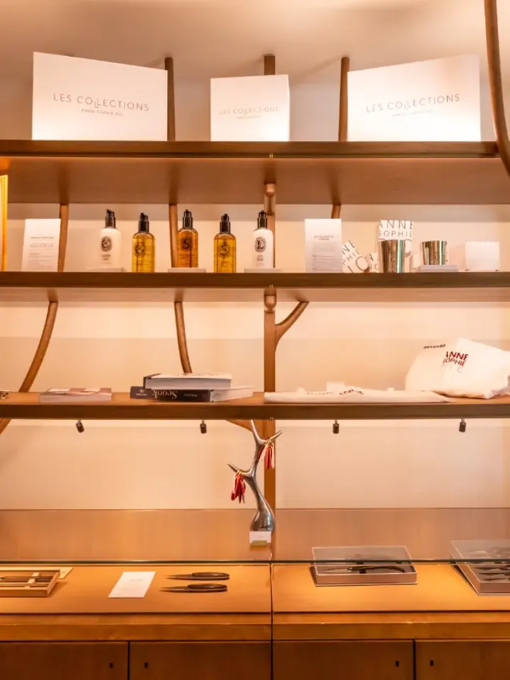 Holzregale mit Schönheitsprodukten, Büchern und Dekorationsartikeln in einem stilvollen Geschäft.