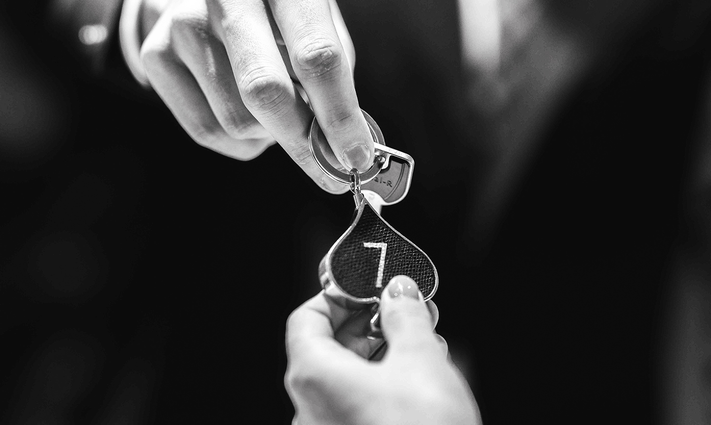 Réceptionniste remettant une clé de chambre à un client.