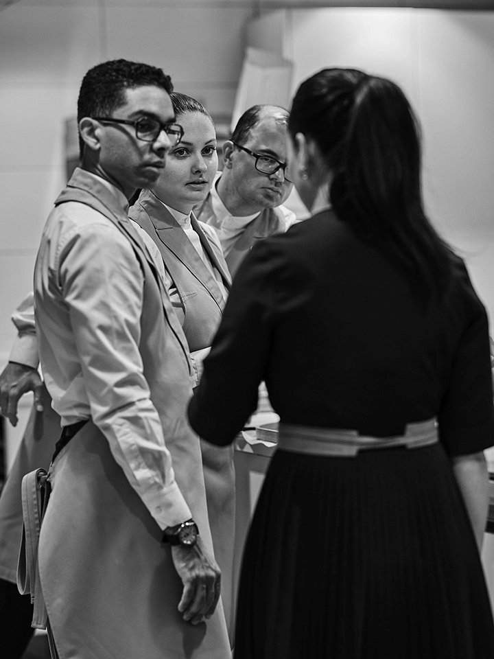 Chef de rang échangeant avec l’équipe en salle avant le service.