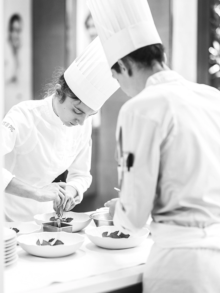 Sous-chef supervisant la préparation et le dressage des plats en cuisine.