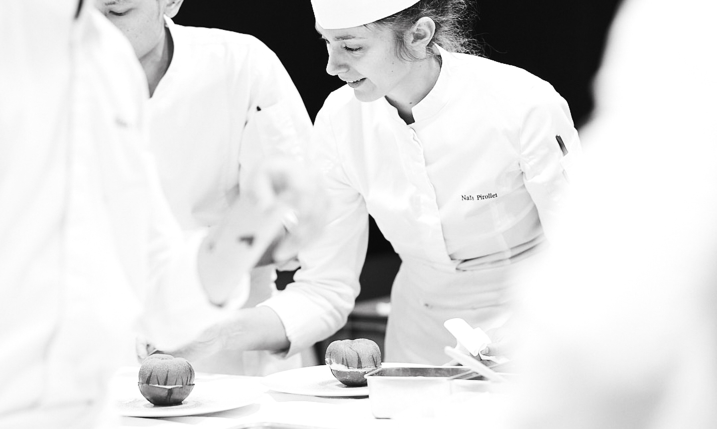 Sous-chef en cuisine préparant des desserts en uniforme blanc